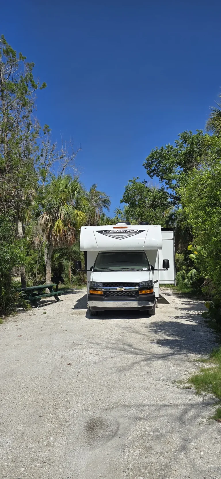 Motorhome estacionado em camping da Flórida com mesa de piquenique e área verde