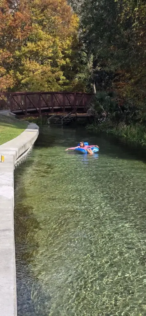 Casal fazendo tubing juntos em boia azul em rio cristalino de spring da Flórida